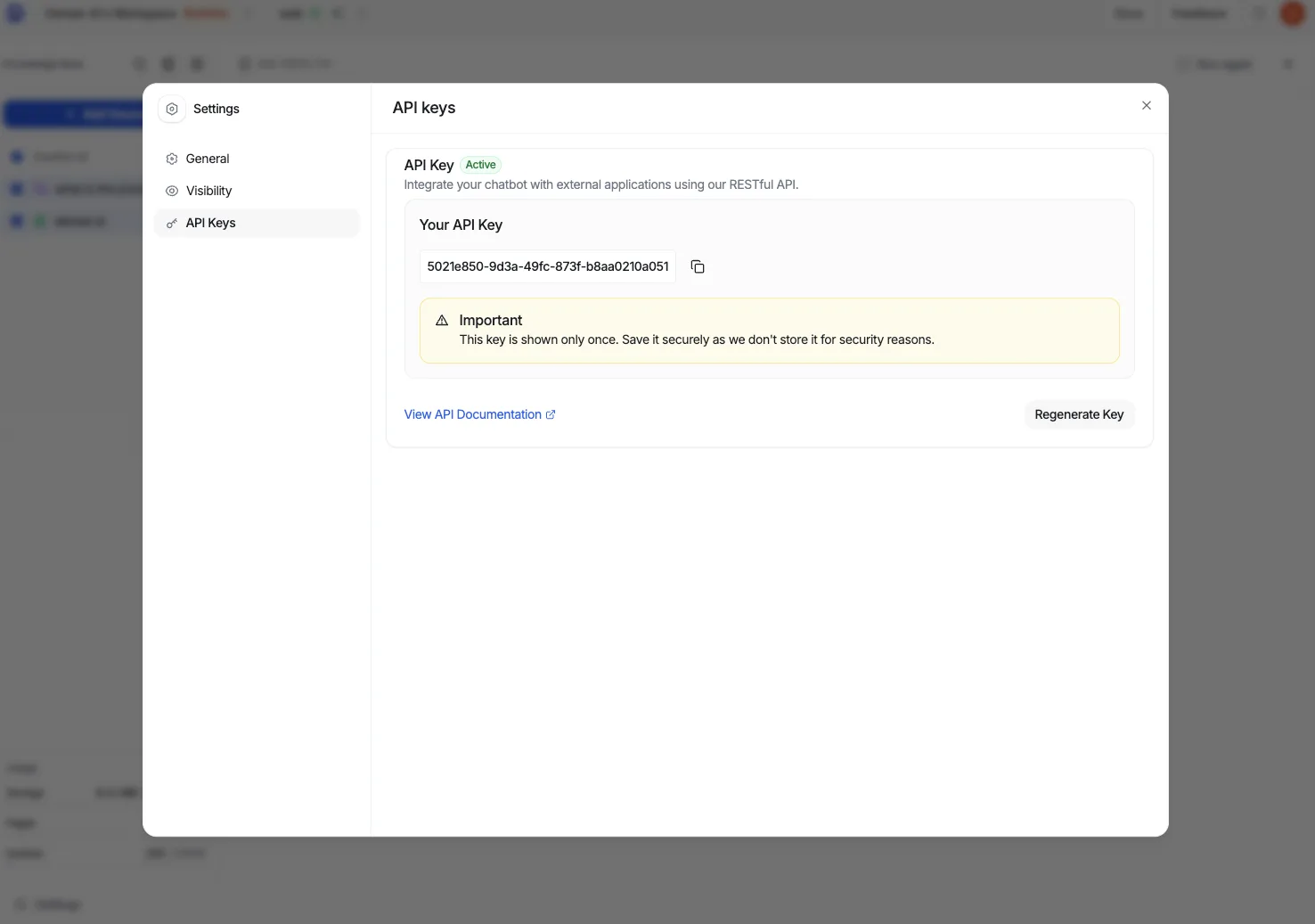 The API Keys panel in Settings showing the chatbot's API key with a copy button, an Active badge, a "shown only once" warning, and a Regenerate Key button